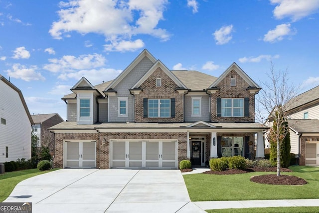 craftsman house featuring brick siding, an attached garage, concrete driveway, and a front lawn