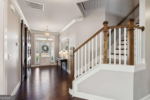 foyer with baseboards, visible vents, dark wood finished floors, ornamental molding, and stairs