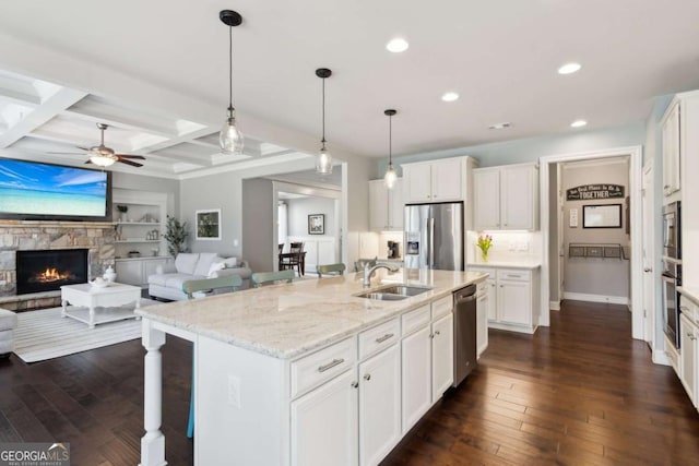 kitchen with dark wood finished floors, coffered ceiling, appliances with stainless steel finishes, and a sink