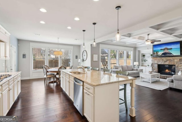 kitchen featuring stainless steel dishwasher, dark wood-type flooring, a kitchen bar, and a sink