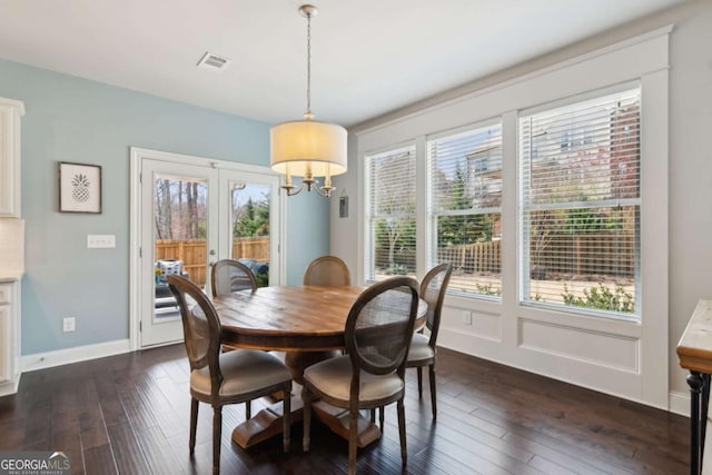 dining room with dark wood-type flooring, plenty of natural light, baseboards, and visible vents