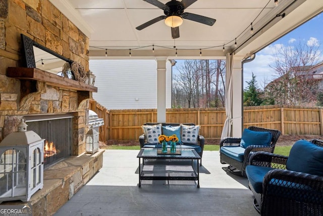 view of patio / terrace featuring an outdoor living space with a fireplace, fence, and ceiling fan