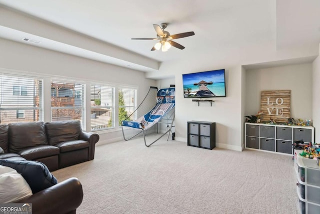 carpeted living room with visible vents, baseboards, and a ceiling fan