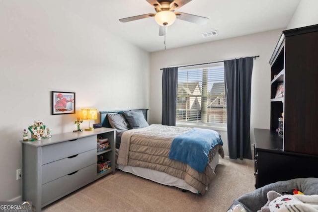 bedroom with ceiling fan, visible vents, and light carpet