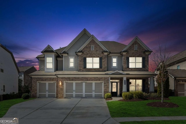 view of front of property with a yard, brick siding, a garage, and driveway