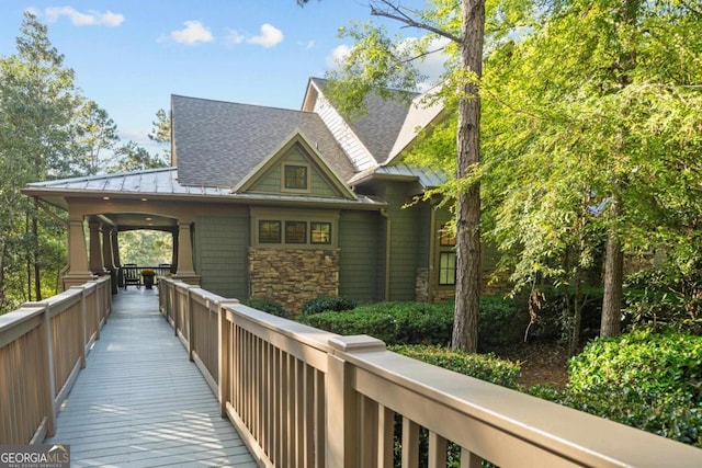 exterior space featuring metal roof, stone siding, and a standing seam roof