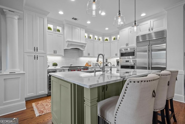 kitchen with visible vents, glass insert cabinets, dark wood finished floors, white cabinets, and a sink