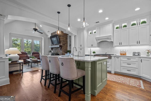 kitchen featuring visible vents, dark wood finished floors, open floor plan, decorative columns, and custom exhaust hood