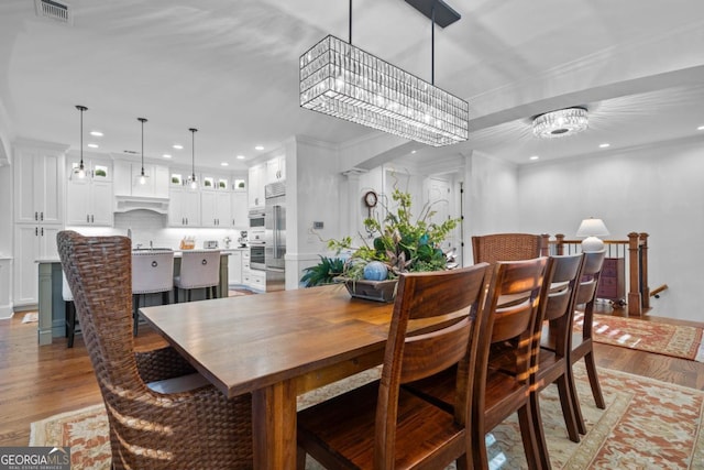 dining area with visible vents, ornamental molding, light wood-style flooring, recessed lighting, and a chandelier