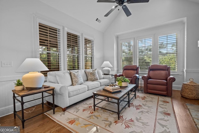 living room with visible vents, ceiling fan, wainscoting, wood finished floors, and high vaulted ceiling