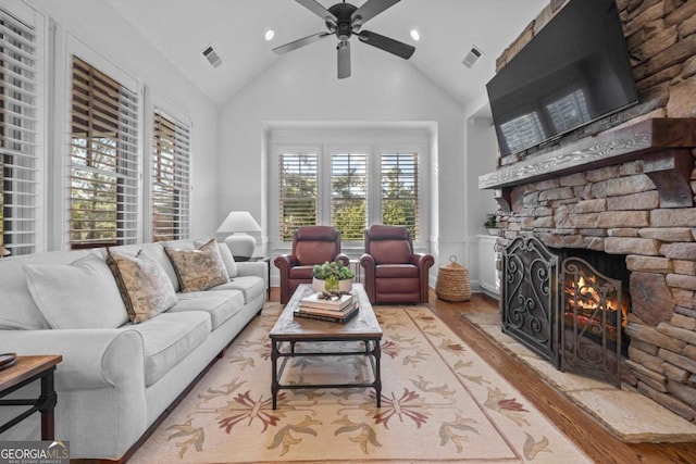 living room featuring visible vents, a ceiling fan, wood finished floors, and a fireplace