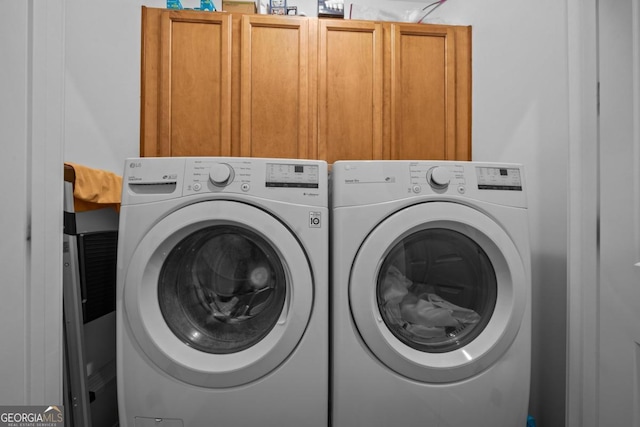 clothes washing area with cabinet space and washing machine and dryer