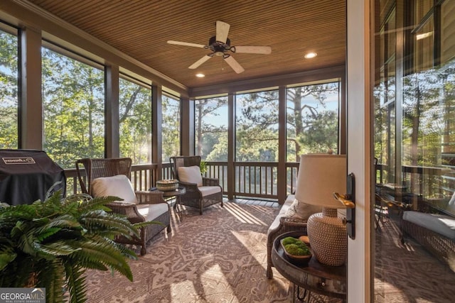 sunroom with plenty of natural light, wood ceiling, and ceiling fan