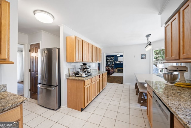 kitchen featuring light stone counters, light tile patterned floors, ornamental molding, appliances with stainless steel finishes, and backsplash