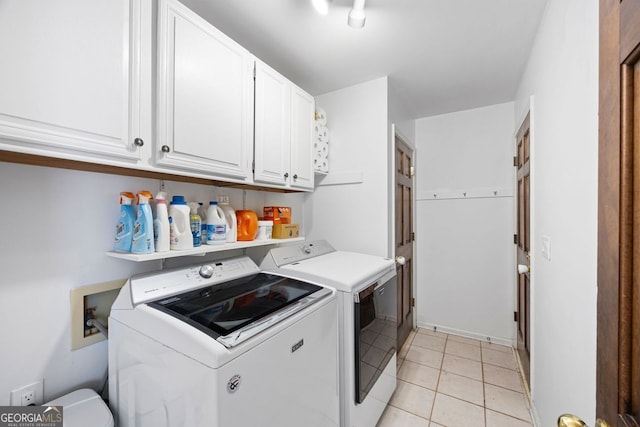 washroom with separate washer and dryer, light tile patterned floors, and cabinet space