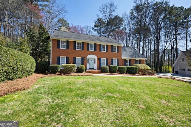 colonial-style house with a front yard and brick siding