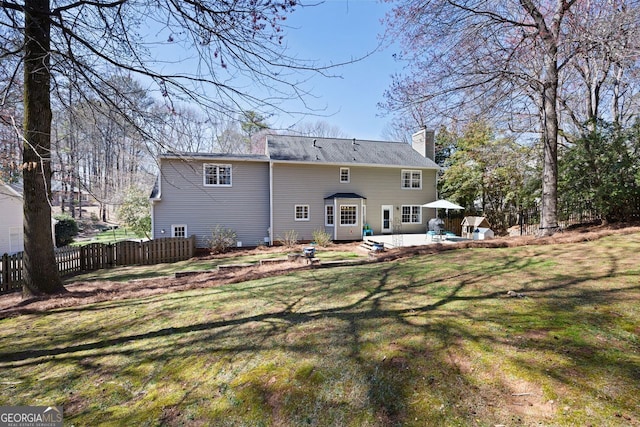 back of house with a patio area, fence, a lawn, and a chimney