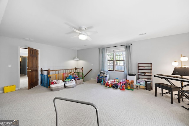 recreation room with a ceiling fan, visible vents, and carpet floors