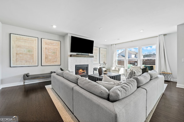 living area with recessed lighting, baseboards, dark wood-style floors, and a fireplace