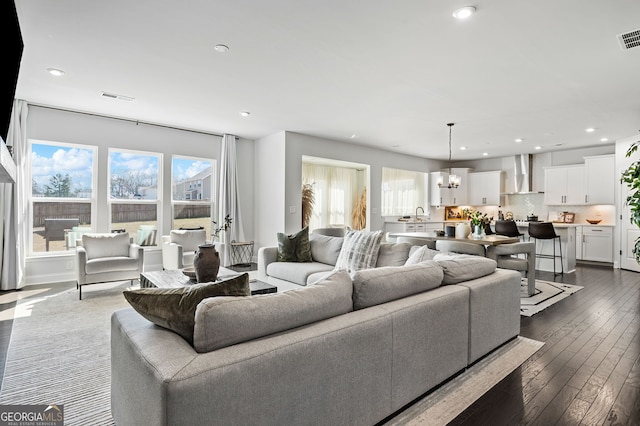 living room featuring recessed lighting, a chandelier, visible vents, and dark wood-style floors
