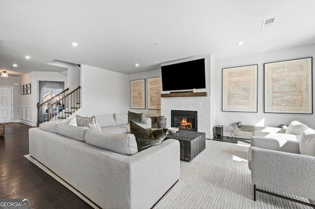 living room featuring visible vents, recessed lighting, wood finished floors, stairway, and a fireplace
