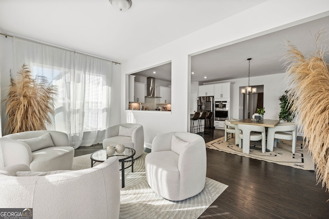 living room with an inviting chandelier and dark wood-style flooring