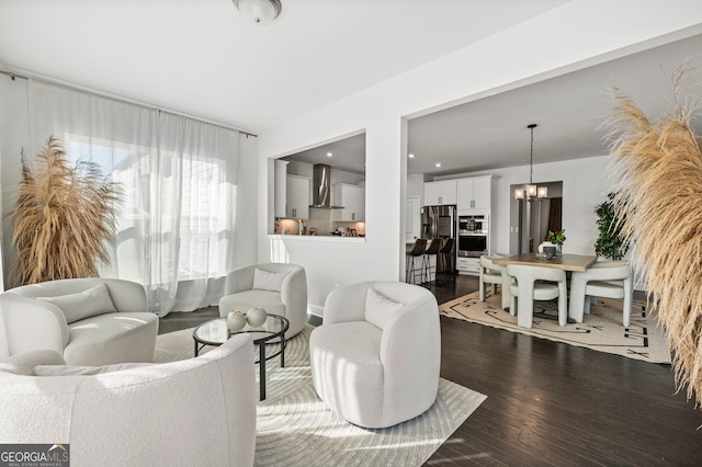 living room with dark wood finished floors and an inviting chandelier