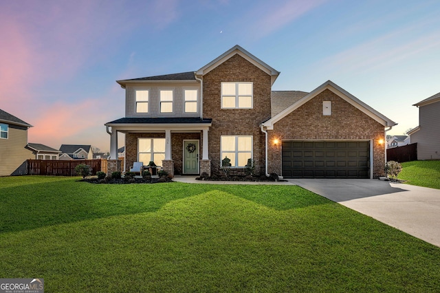 traditional-style house with fence, concrete driveway, an attached garage, a lawn, and brick siding