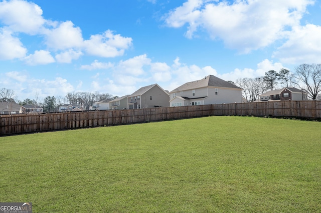 view of yard featuring a fenced backyard and a residential view