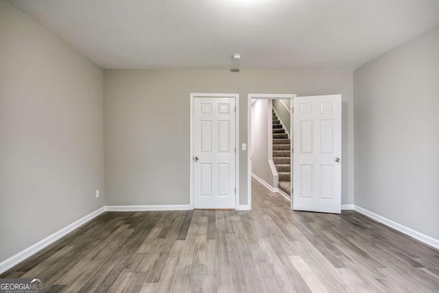 unfurnished bedroom featuring wood finished floors and baseboards