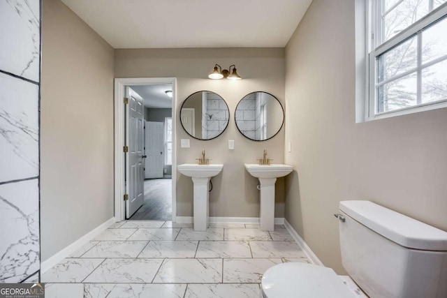 bathroom with marble finish floor, toilet, and baseboards