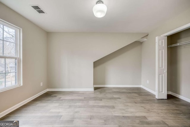 interior space featuring visible vents, multiple windows, and wood finished floors