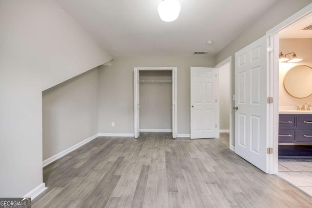 bonus room featuring visible vents, baseboards, light wood-style floors, and a sink