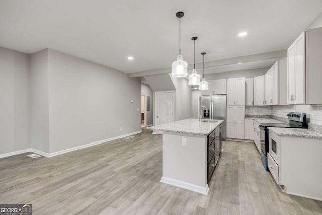 kitchen with light wood finished floors, backsplash, pendant lighting, appliances with stainless steel finishes, and a sink