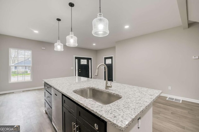 kitchen with baseboards, visible vents, a sink, dishwasher, and light wood-type flooring