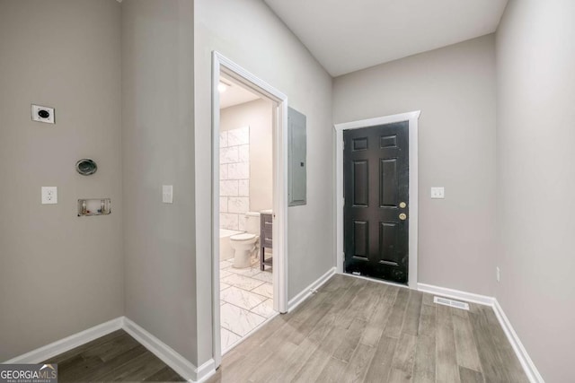 entryway featuring electric panel, visible vents, baseboards, and wood finished floors