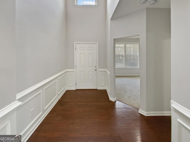 hallway featuring a decorative wall and wood finished floors