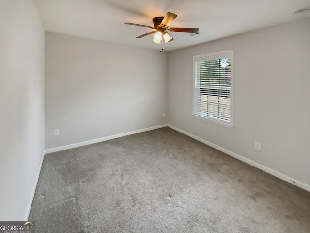 carpeted spare room featuring a ceiling fan, baseboards, and visible vents