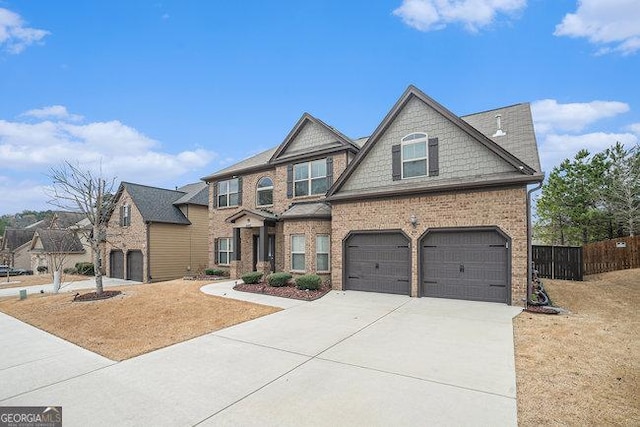 craftsman house with brick siding, driveway, an attached garage, and fence