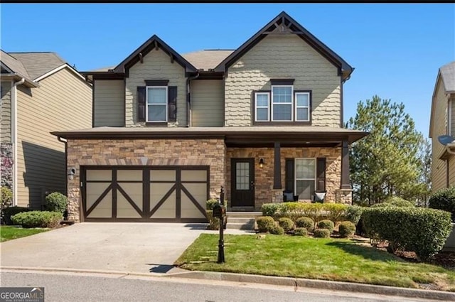 craftsman house with stone siding, driveway, an attached garage, and a front yard