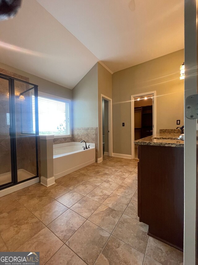 5928 Cobblestone Creek Cir, Mableton, GA 30126 - bathroom featuring vanity, baseboards, vaulted ceiling, a stall shower, and a bath