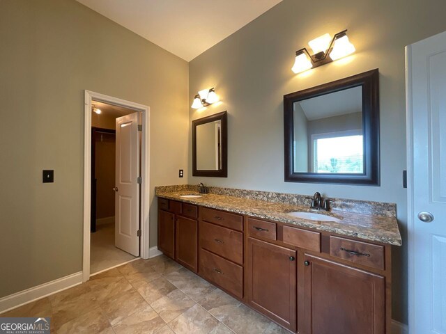 5928 Cobblestone Creek Cir, Mableton, GA 30126 - bathroom featuring a walk in closet, double vanity, a sink, and baseboards
