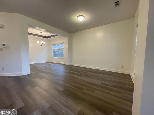 5928 Cobblestone Creek Cir, Mableton, GA 30126 - empty room with visible vents, baseboards, a notable chandelier, dark wood finished floors, and a tray ceiling