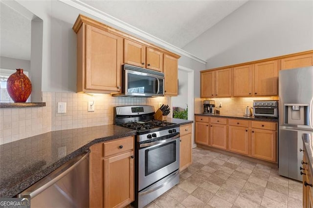 kitchen with tasteful backsplash, dark stone counters, appliances with stainless steel finishes, a toaster, and vaulted ceiling