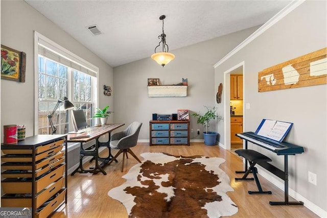 office space with visible vents, lofted ceiling, light wood-style floors, and baseboards