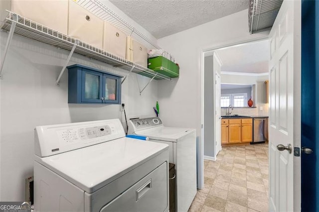 washroom featuring a sink, a textured ceiling, washing machine and dryer, and laundry area