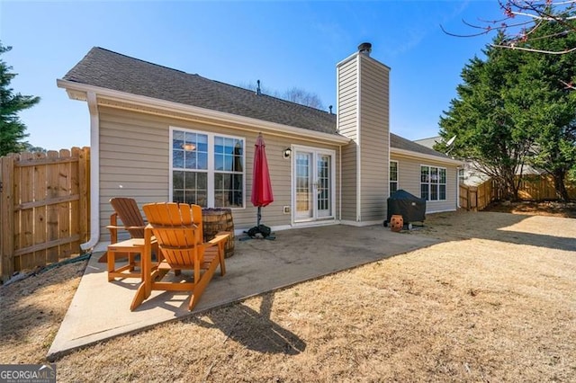 back of property featuring a patio, fence private yard, french doors, and a chimney