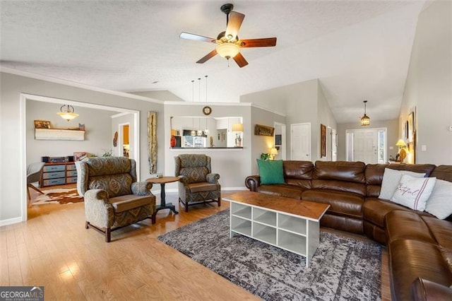 living room featuring baseboards, wood finished floors, a ceiling fan, and vaulted ceiling