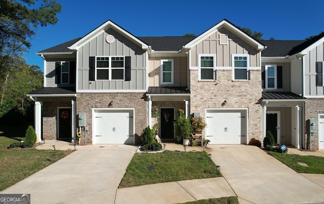 multi unit property featuring brick siding, board and batten siding, concrete driveway, and a standing seam roof