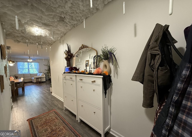 corridor with dark wood-style floors and baseboards